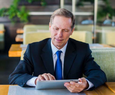 Chief Executive using Convene on his tablet to review board documents Chief Executive using Convene on his tablet to review board documents